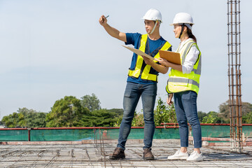 Teamwork of civil technician engineer and professional architect working together to inspect and discuss the infrastructure of building material construction progress at site
