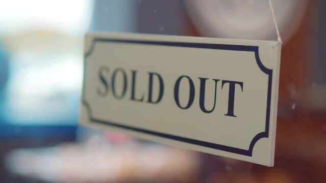 Small business owner hang sold out sign on glass door of bakery or coffee shop. Realtime