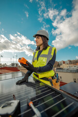Female electrician engineer using Multimeter on domestic urban Solar Panels