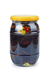 Dried plums in glass jar with oil isolated on a white background