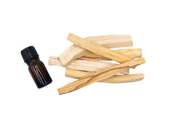 Palo Santo (Holy Stick) Essential Oil Extract Essense in a Bottle with Palo Santo sticks beside it. Close up shot isolated on White Background.