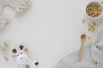Kids breakfast concept, flat lay composition with cereal, wooden spoon, toys, free space in the middle for text or product presentation.