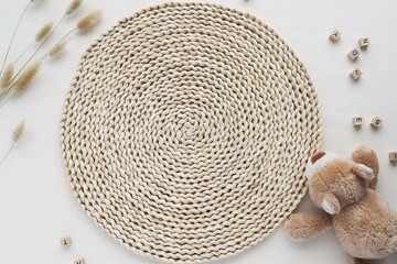 Still life flat lay with wicker mat, dried plants, soft toy, background for kids activity design,...