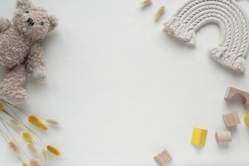 Childhood background, bohemian styled flat lay with toys and macrame rainbow, space for text in the...