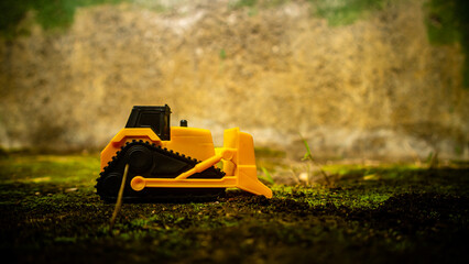 South Minahasa, Indonesia : January 2023, a yellow bulldozer toy is leveling the ground