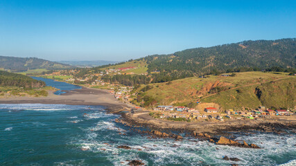aerial horizontal photo from drone, fishermen's cove in the city of boyeruca with the lagoon in the background and the sea, sixth region, chile