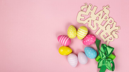 Fototapeta na wymiar greeting card with text happy easter. multicolored easter eggs on pink background