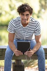 Fototapeta premium man on a bench using a tablet