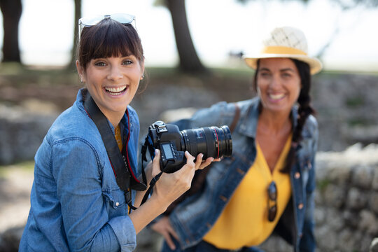 happy women taking photos during trip