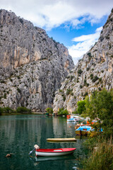 panorama of the town of omis in croatia on the adriatic coast; the famous old town at the mouth of the cetina river; old buildings surrounded by huge mountains in a canyon