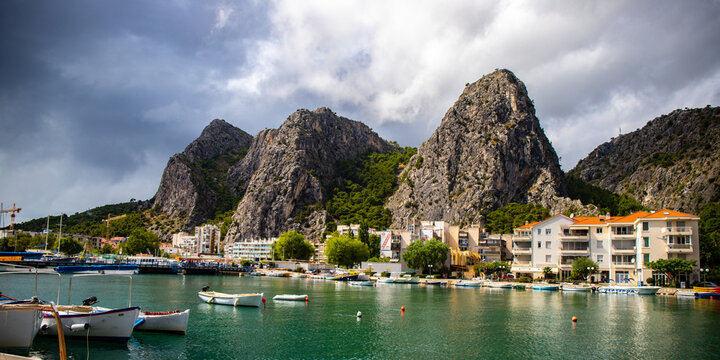 panorama of the town of omis in croatia on the adriatic coast; the famous old town at the mouth of the cetina river; old buildings surrounded by huge mountains in a canyon