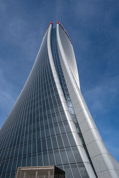 Milan, Italy - October 30, 2022. CityLife district,  Lo Storto skyscraper (The Twisted One), reflections against blue sky, (Generali Tower designed by Zaha Hadid), Lombardy
