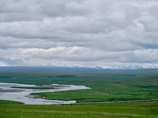 Snow covered Brooks Range with the Alaska Pipeline traveling North and south over the treeless...
