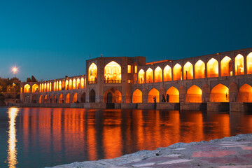 Isfahan, Iran - 15th june, 2022: tourist muslim visit Old Khajoo bridge at night, across the Zayandeh River in Isfahan, Iran.