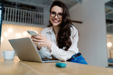 Glad young woman using modern devices