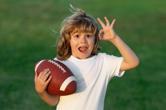 Kids and sports. Young boy playing american football. Kid boy playing with rugby ball in park. Child holding rugby ball while playing american football in Summer park.