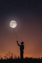 Fantastic photo of the silhouette of a girl holding the moon like a ball on a rope. Abstraction...