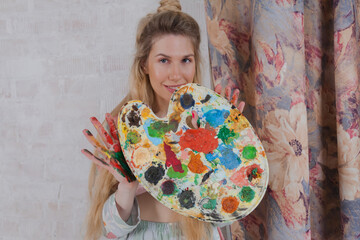Talented Female Artist smiling happy showing palette with paint. Colorful, Emotional, Sensual...