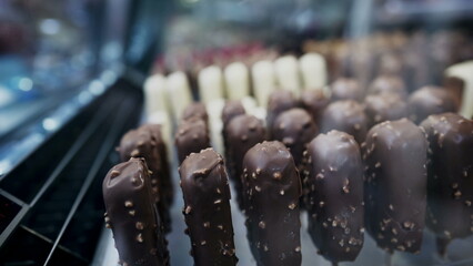 Chocolate and vanilla stick ice cream on display in street behind refrigerator glass
