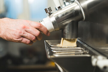Pouring ice cream from pasteurizer and batch freezer machine. High quality photo