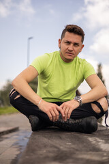 serene young guy with short hair and wearing casual clothes with t-shirt, sitting resting in the city in the daytime, lifestyle of male model