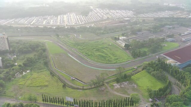 4K footage aerial view of Sentul Circuit in the morning when it's foggy and the sun's rays are slightly covered by clouds.