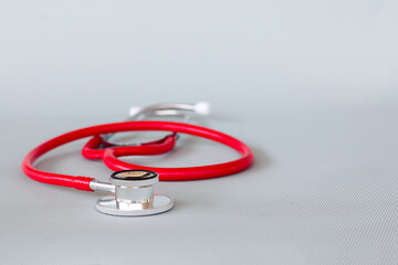 Fototapeta na wymiar red stethoscope on gray background ,health care concept.