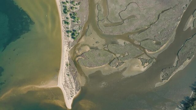 Aerial shot of a beach with a river delta behind it