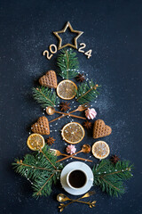 2024 Christmas tree made of sweets, spices and coffee on a dark background.