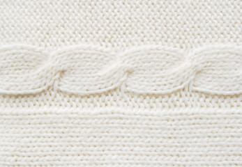 Fototapeta na wymiar Soft ivory woolen sweater surface with cable ornament texture as background
