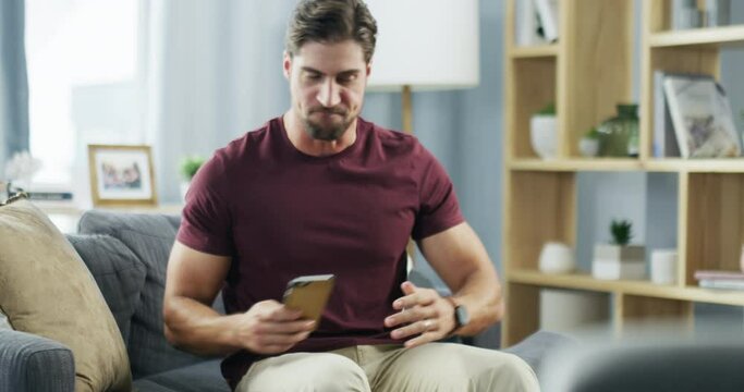 Angry, stress and frustrated man hanging after phone call in his living room at home. Male with anger and sad after relationship argument, fight or breakup on mobile smartphone on the couch