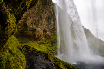 Seljalandsfoss Iceland is a stunning waterfall that allows visitors to walk behind the cascading water.