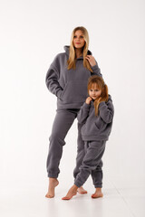 Sporty mom and her little daughter in thermal clothes.