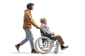 Full length profile shot of an african american young man pushing an elderly man in a wheelchair