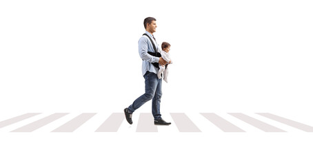 Full length profile shot of a father with a baby in a carrier crossing over pedestrian zebra sign © Ljupco Smokovski