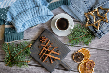 Christmas tree made of cinnamon sticks and black coffee, sweater, jeans on a wooden table.
