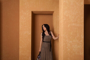 A woman wearing dress in a beige sandstone room. warm and cozy atmosphere.