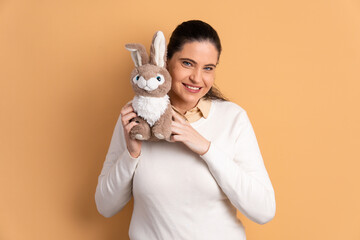 happy mature woman with easter bunny in beige colors. holiday, easter, celebration concept.