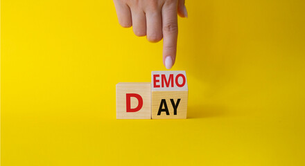 Demo Day symbol. Businessman hand points at turned wooden cubes with concept words Demo Day....