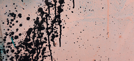 Pink painted grunge plaster wall surface background with black color drips, flows, streaks of paint...
