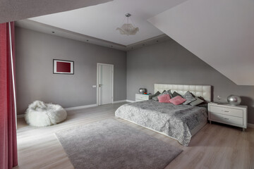 Beautiful interior design of a modern and cozy bedroom with pink pillows and curtains