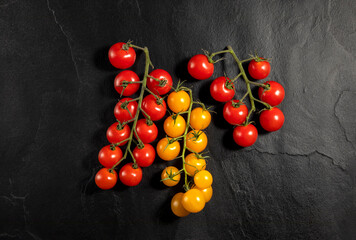 Fototapeta na wymiar red and yellow tomatoes on black background