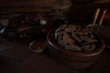 Wooden bowl with round rye bread on a dark table, ecological, healthy food