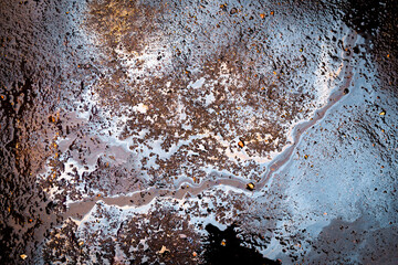 Gasoline stain on the roadway. Oil petrol water pollution.
