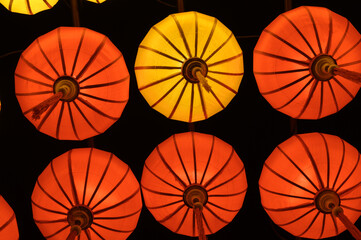 Low angle of red and orange sky lanterns flying up at night in Vietnam