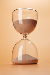 Hourglass with clean sand pouring down countdown the time, isolated on the bright solid fond plain...
