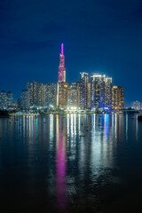 Obraz premium Amazing view of modern megapolis with skyscrapers illuminated with lights placed near calm river