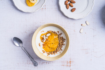 Yogurt granola bowls with  orange fruits,  top view. Healthy vegetarian breakfast meal