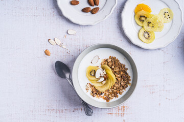Yogurt granola bowls with kiwi  fruit,  top view. Healthy vegetarian breakfast meal