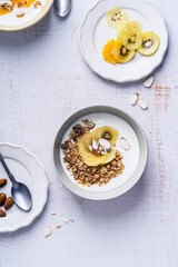 Yogurt granola bowls with kiwi  fruit,  top view. Healthy vegetarian breakfast meal